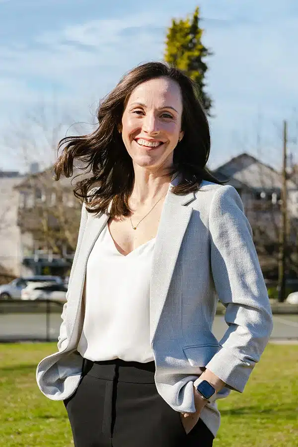 Team Portrait of Lyndsey Dyer, standing in a business suit in a park.