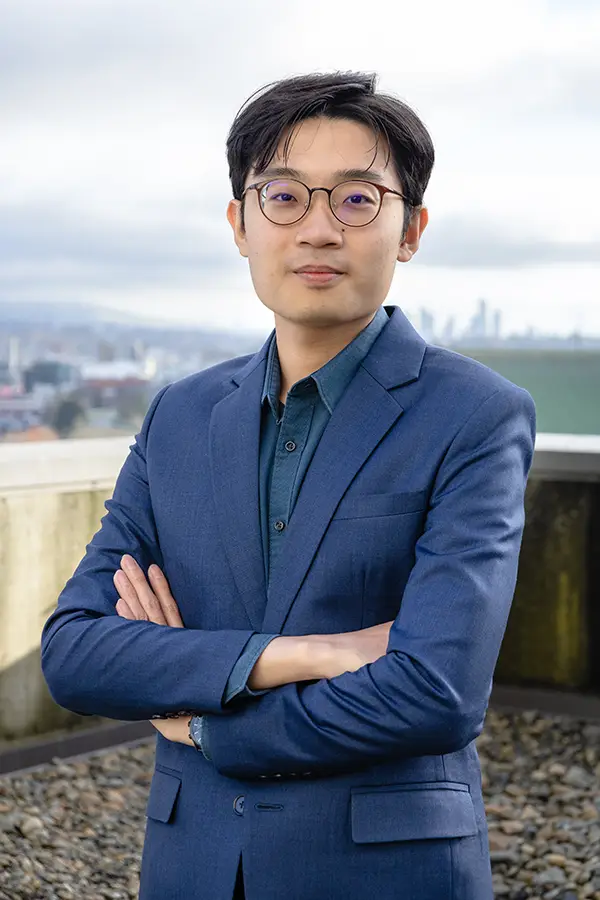 Team Portrait of Lucian Lee, Program Manager at The Coaching Studio, standing in front of the Vancouver Skyline